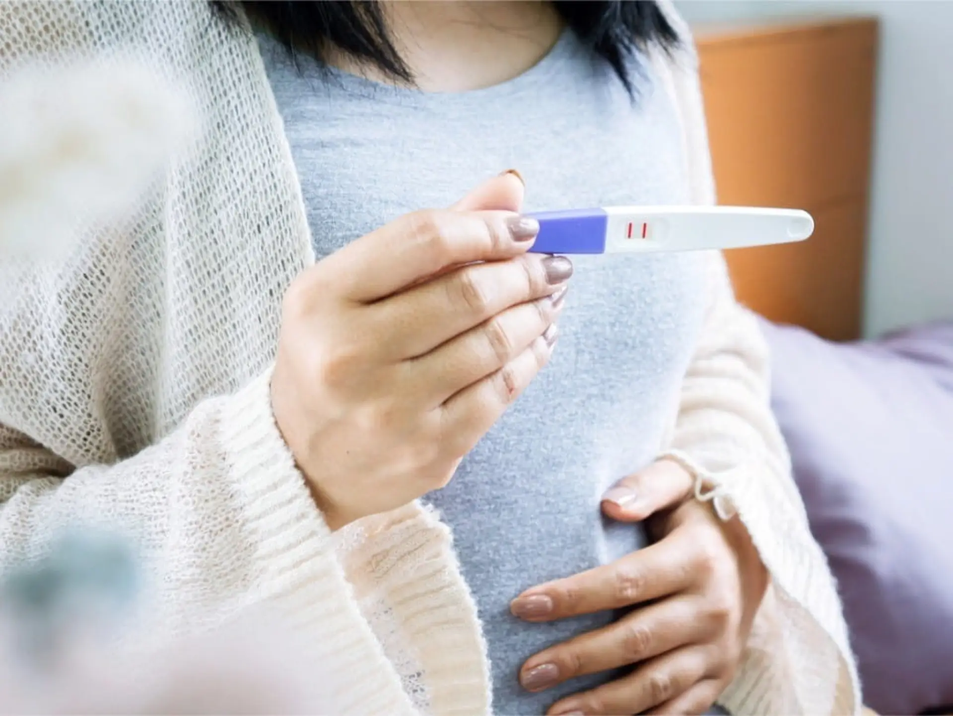 woman holding positive pregnancy test