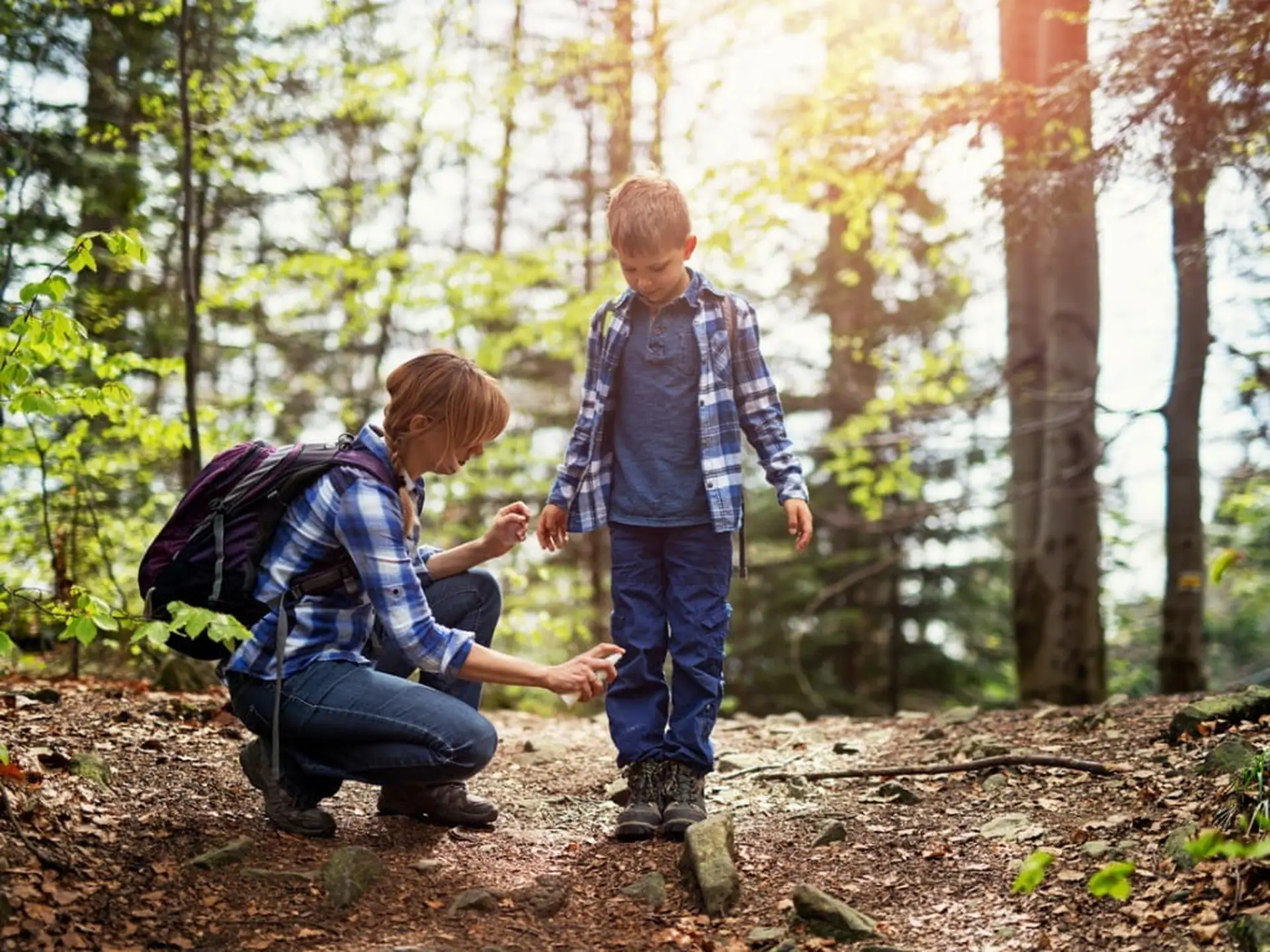 mother applying tick repellent on son