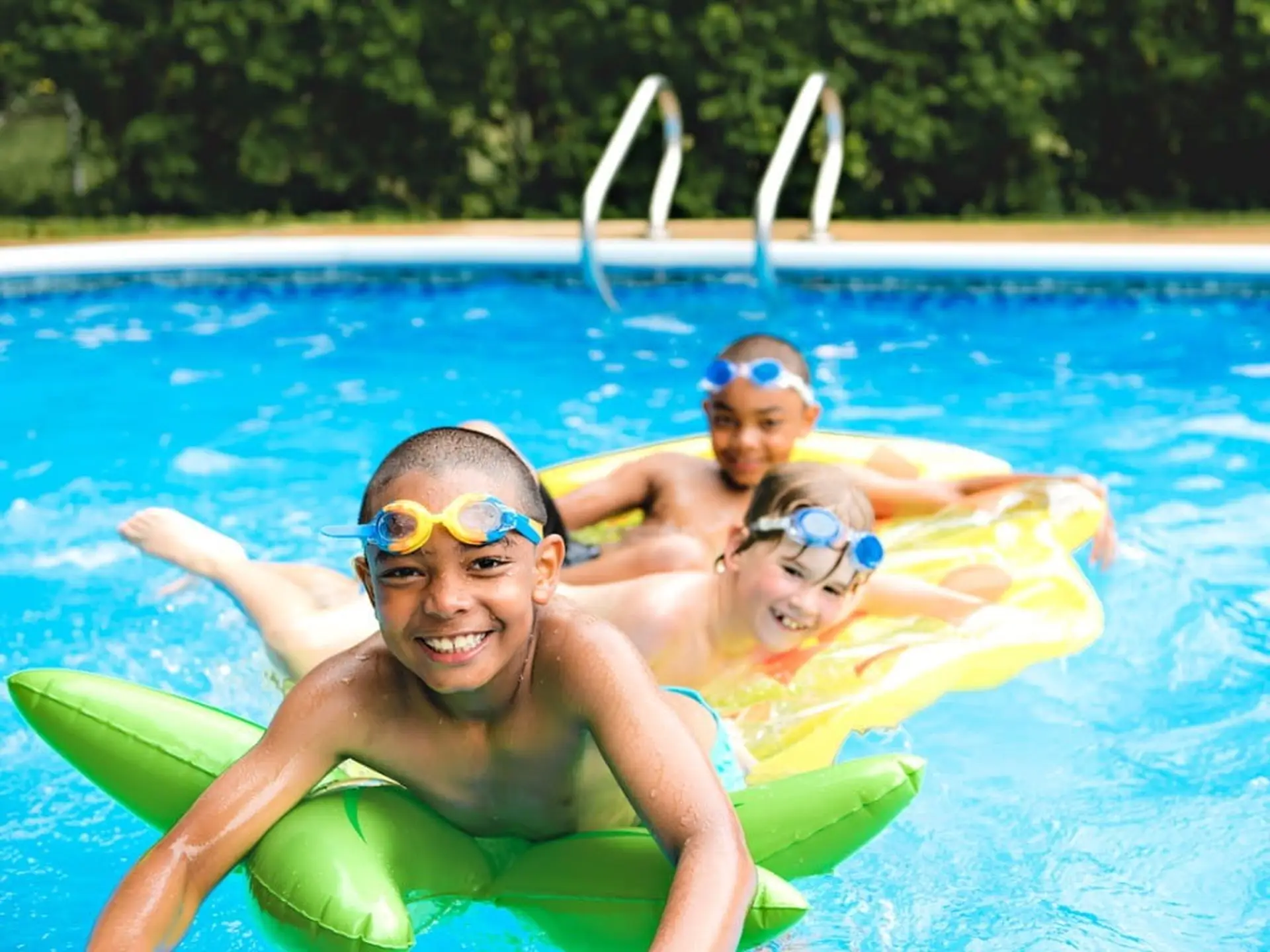 three kids swimming in the pool