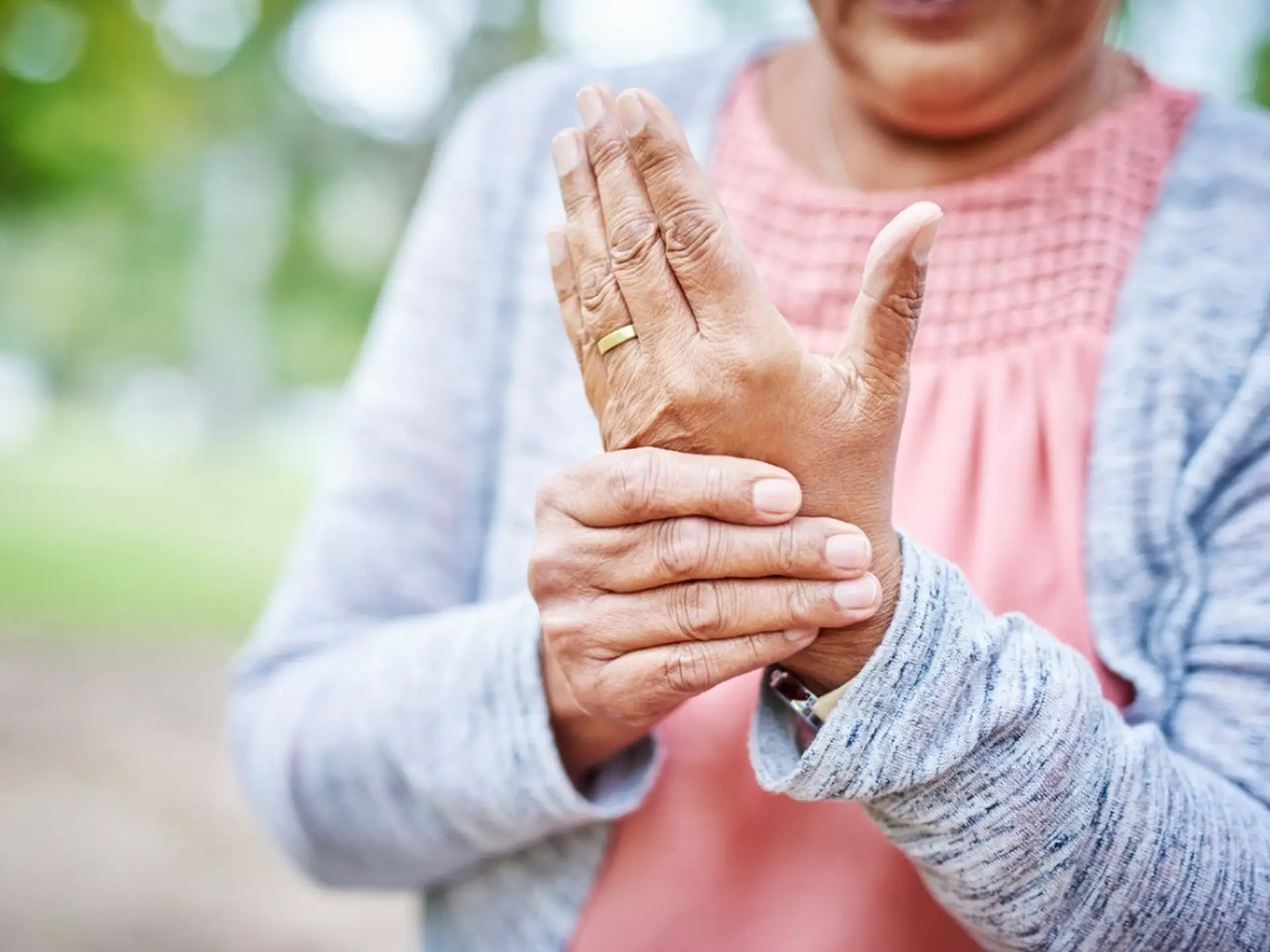 woman holding hand with arthritis