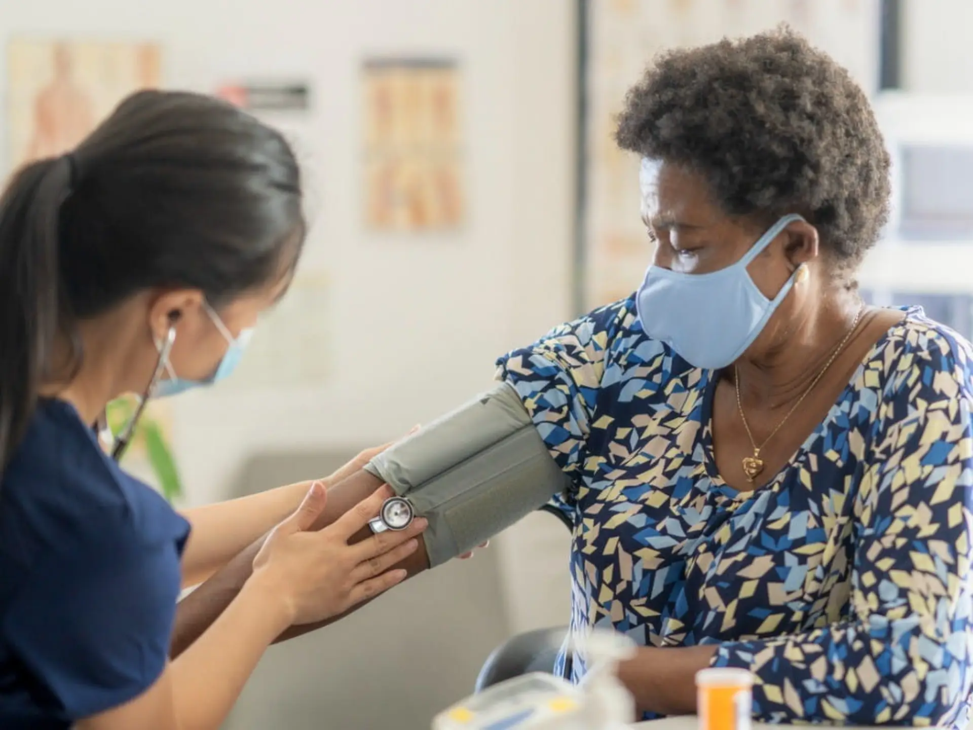 nurse taking older womans blood pressure