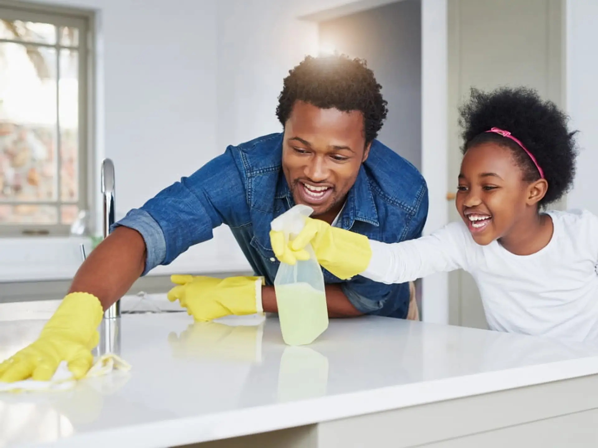 father and daughter cleaning countertop