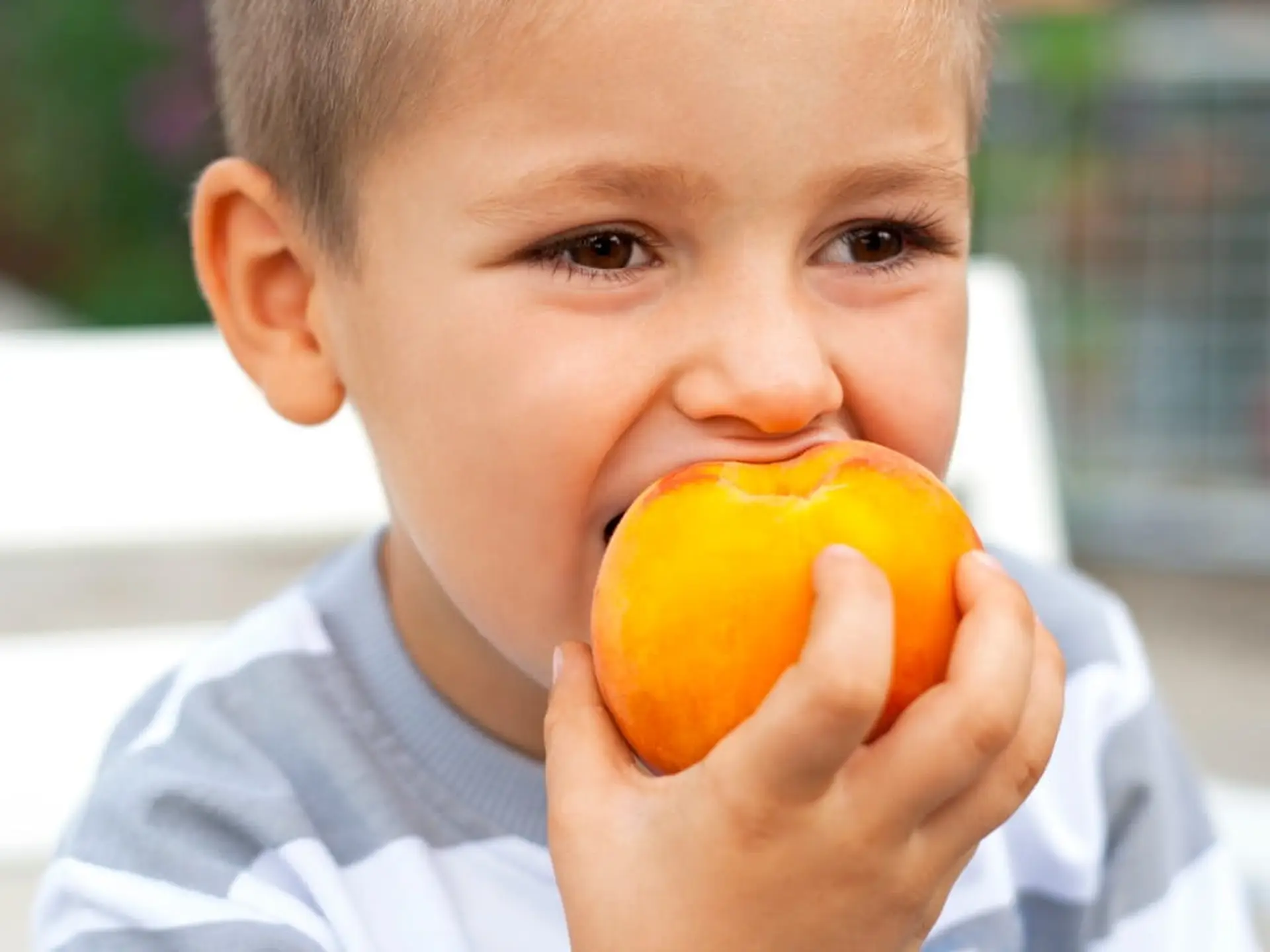 boy eating a peach