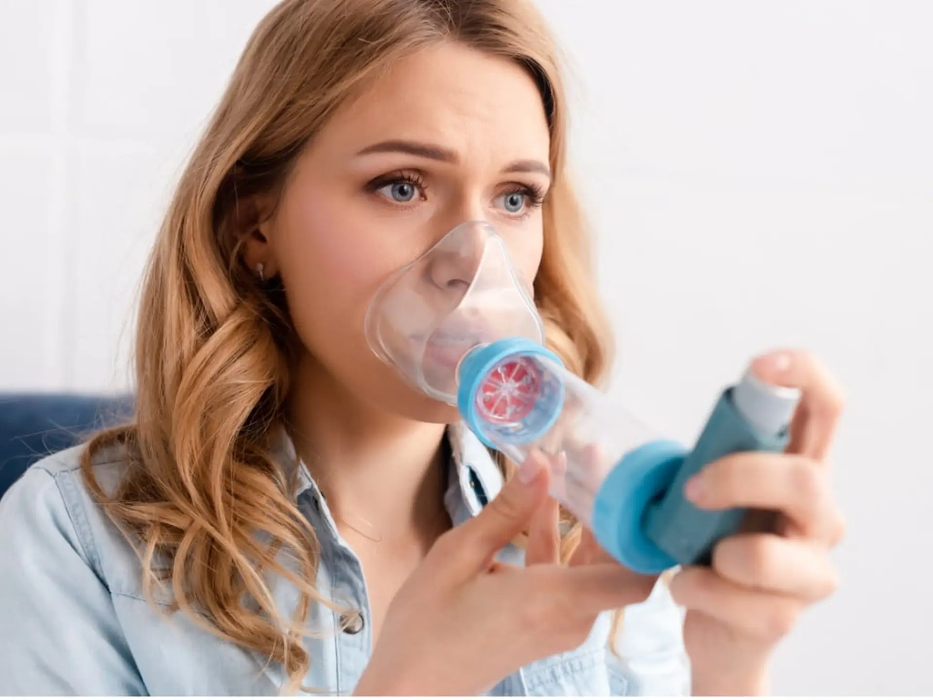 Woman using inhaler with spacer