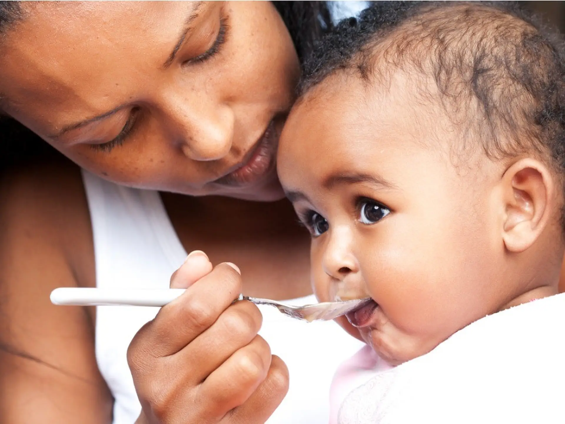 mother feeding infant rice cereal
