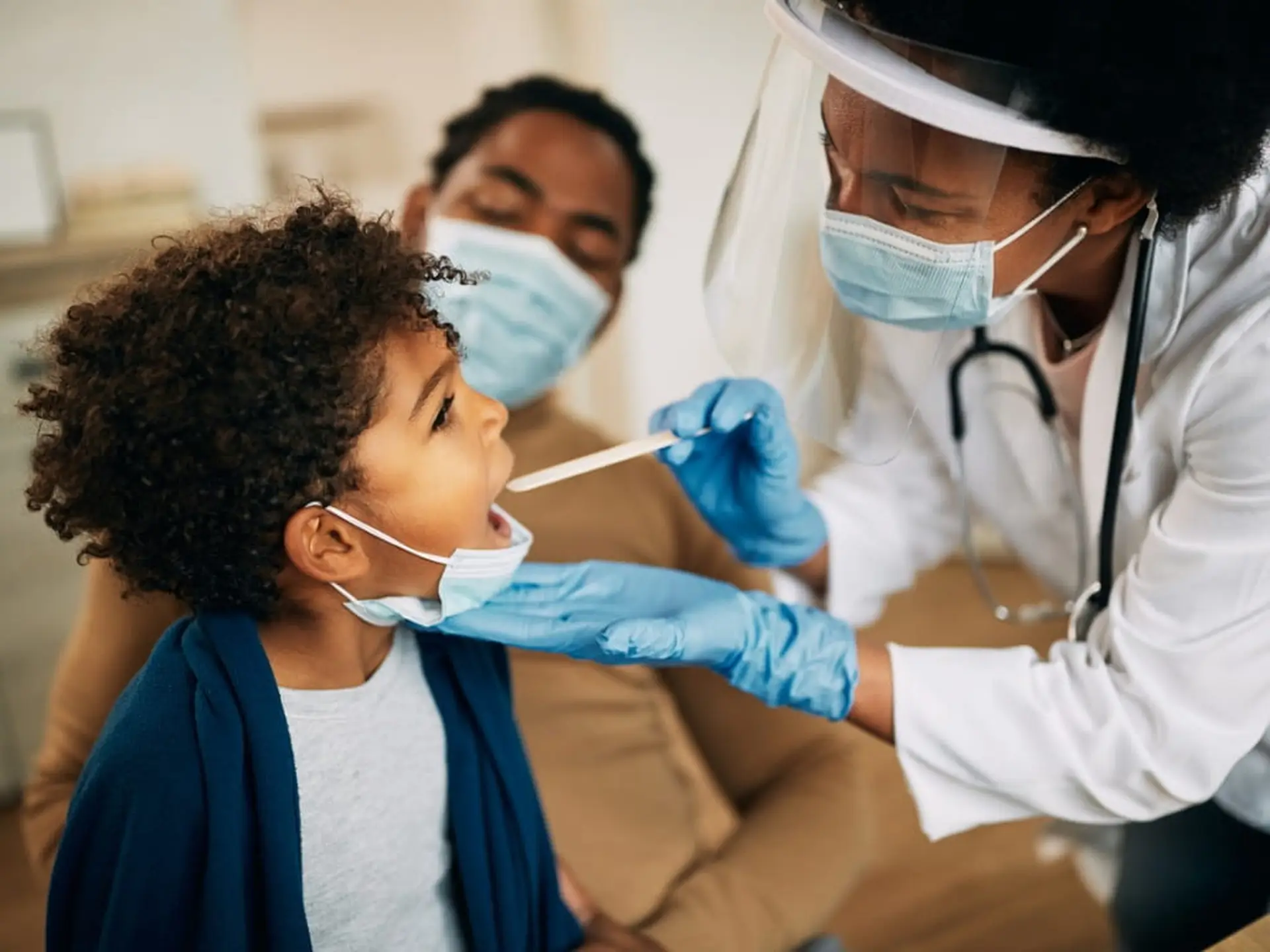 doctor examining child's throat