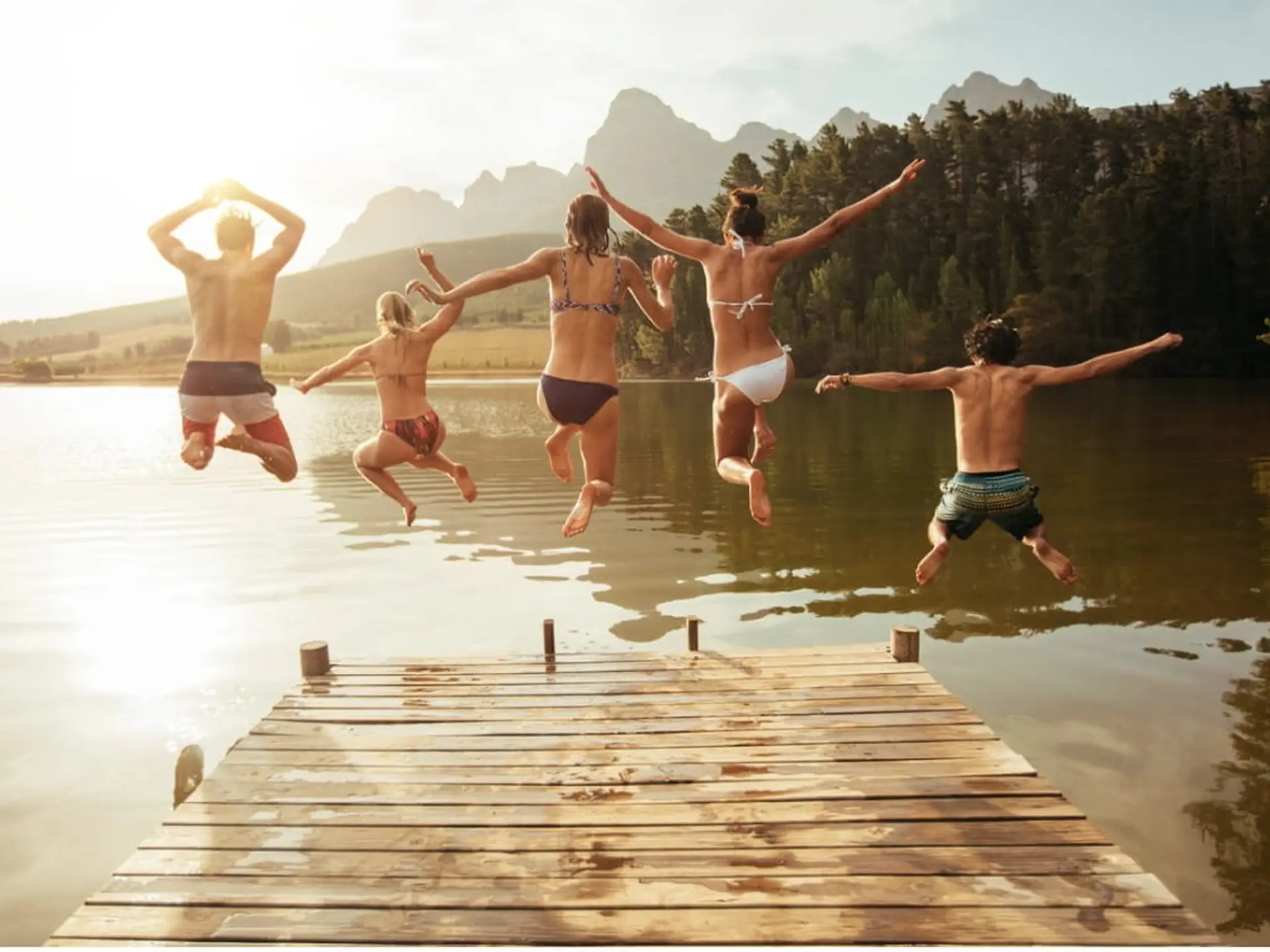 group jumping into a lake