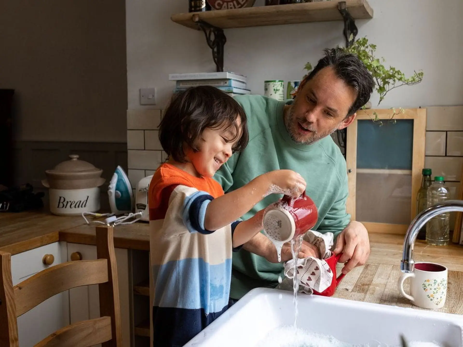 Father and son washing mugs