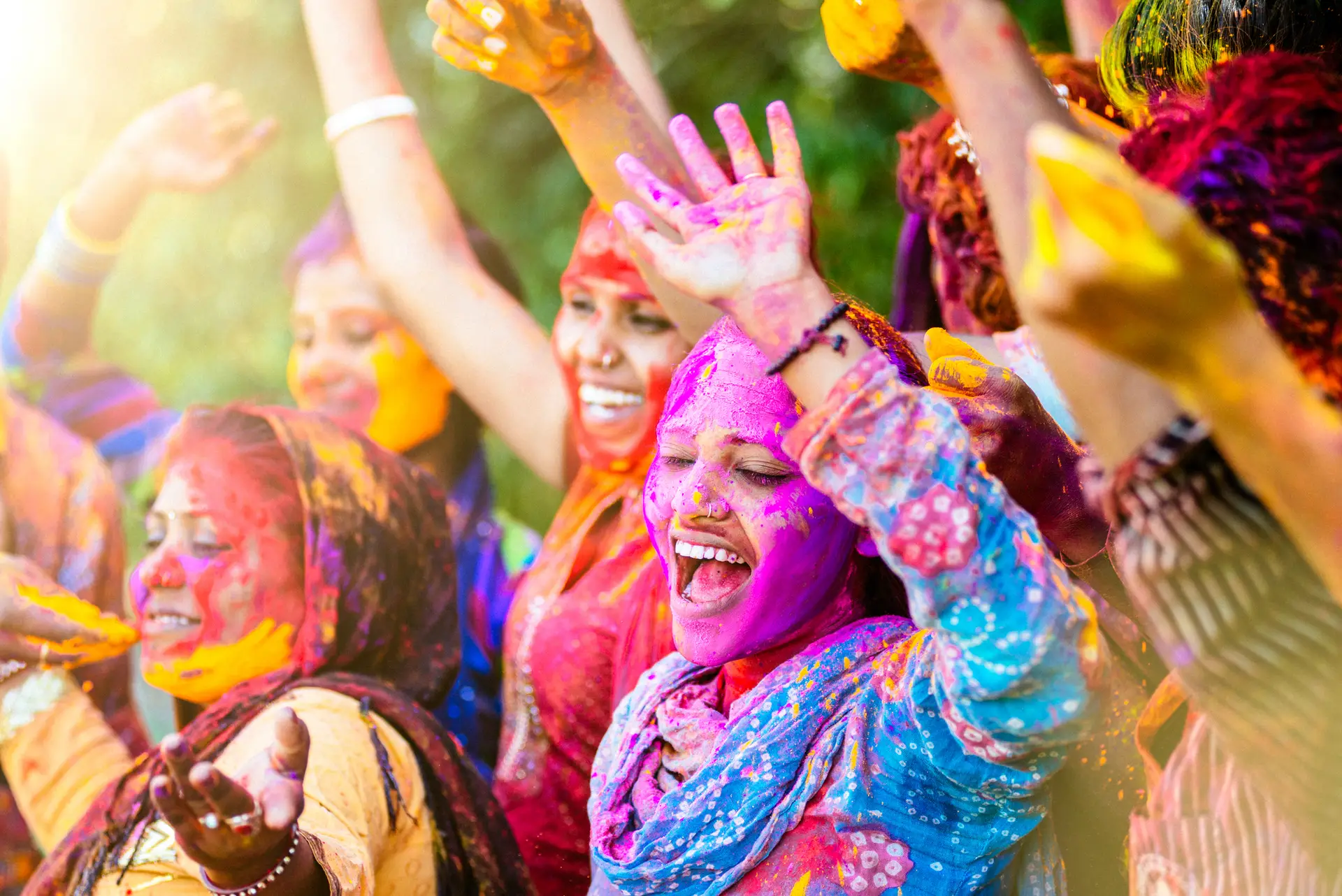 women throwing colored Holi powder