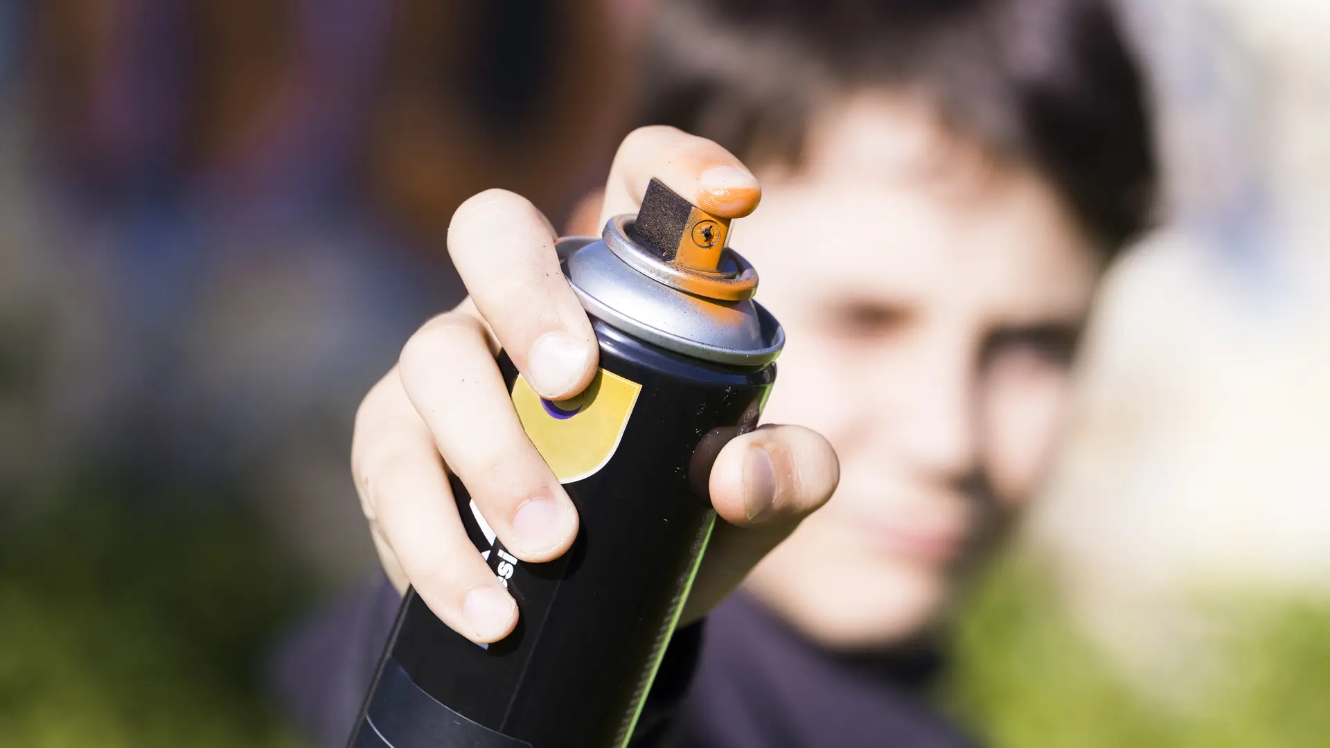 teen holding a spray paint can