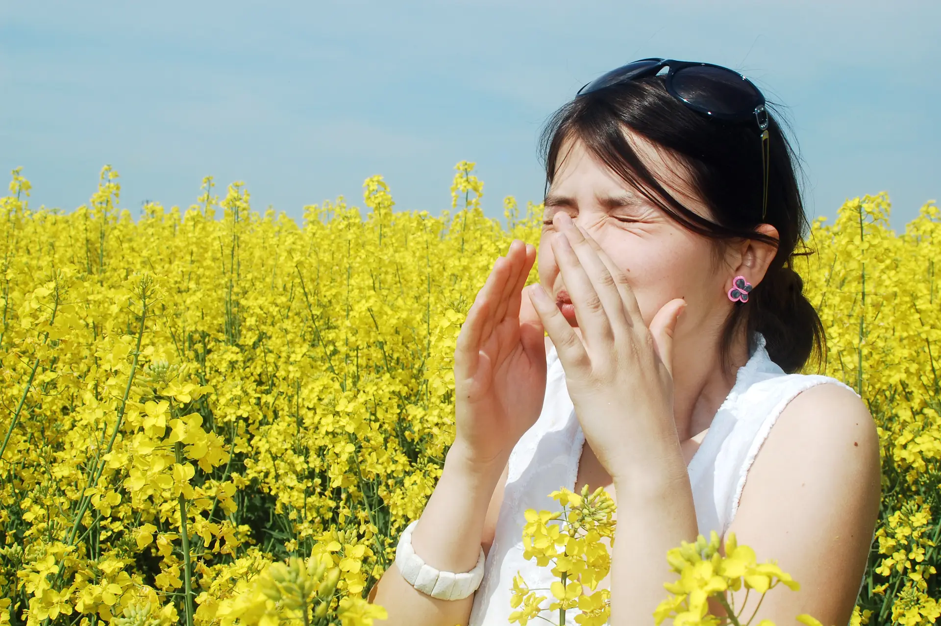 woman sneezing in a field