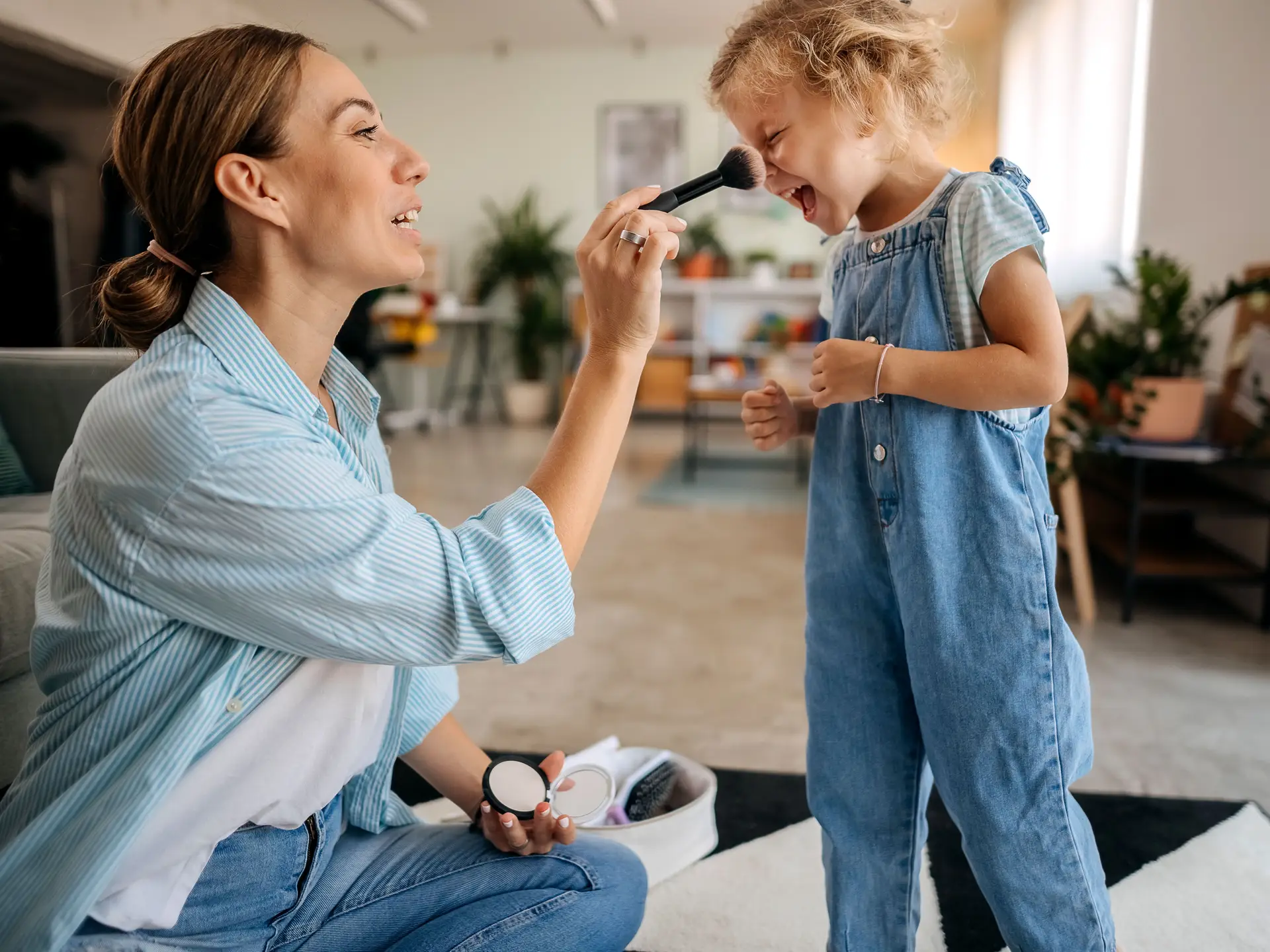mother applying makeup on daughter's face
