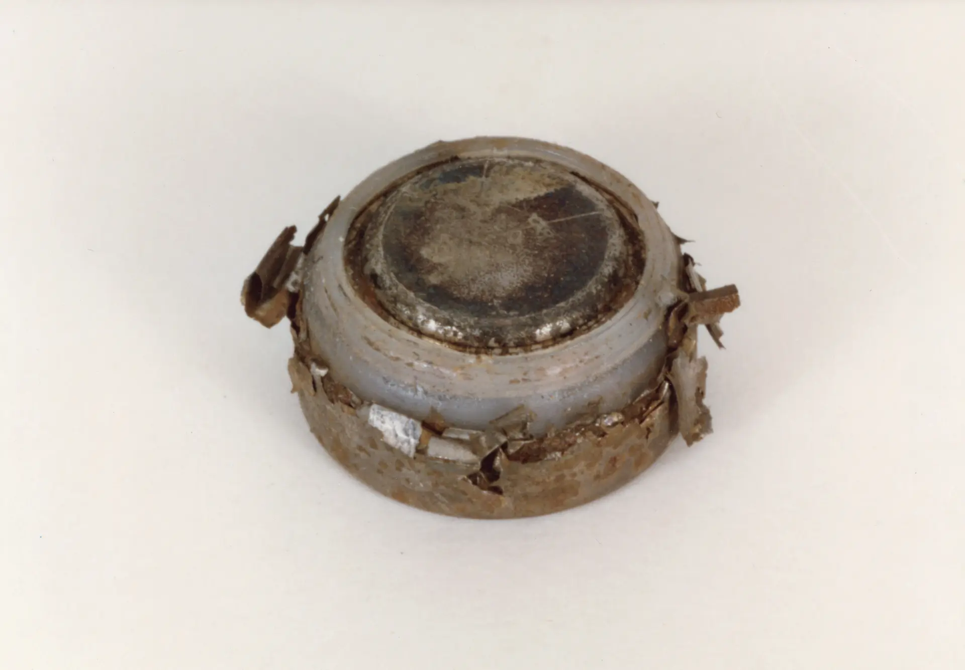 button battery with severe crimp dissolution